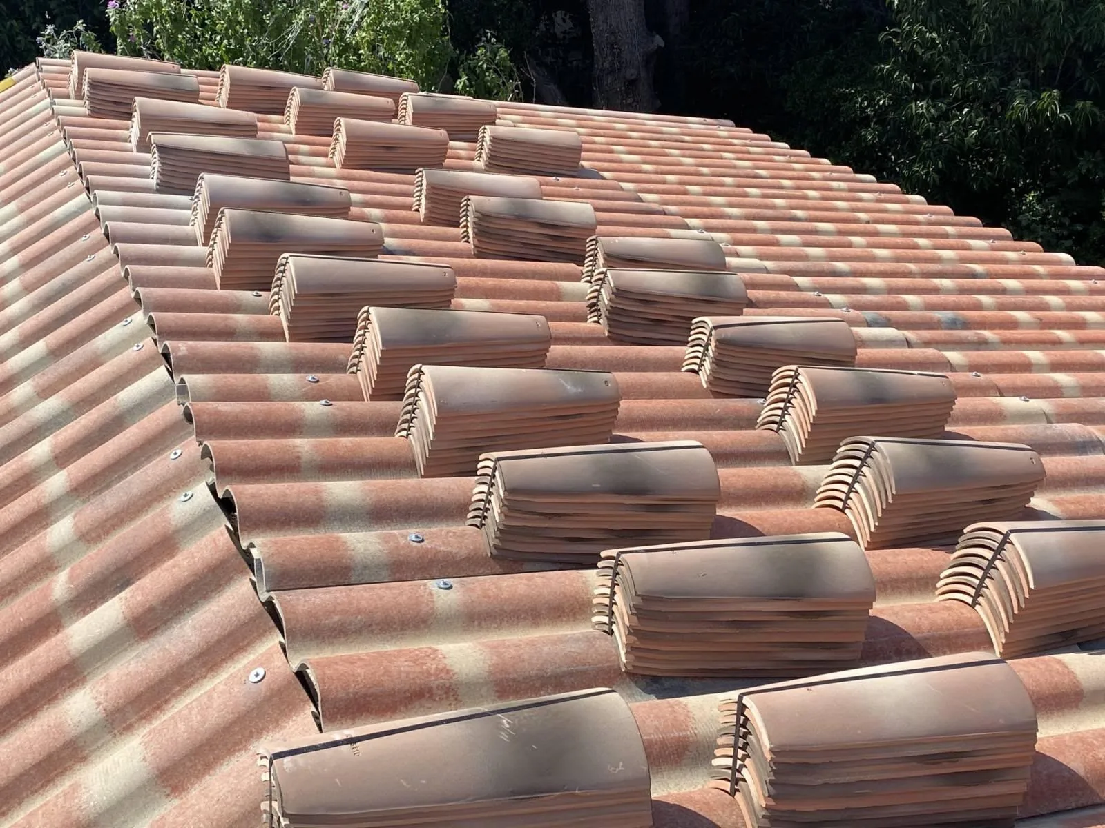 Pose de tuiles en cours sur plaques de sous-toiture, chantier dans le Var